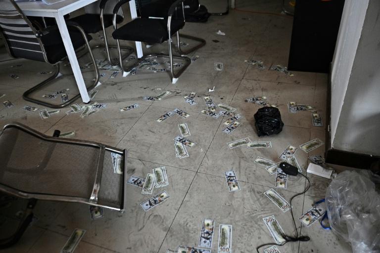 法新社报道:奥斯玛的皇家山庄园区狗推在泰国轰炸前逃跑,留下一地假的美钞。